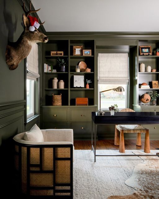 a living room filled with furniture and lots of green bookshelves covered in deer heads