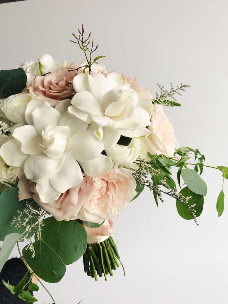 a bouquet of white and pink flowers with greenery