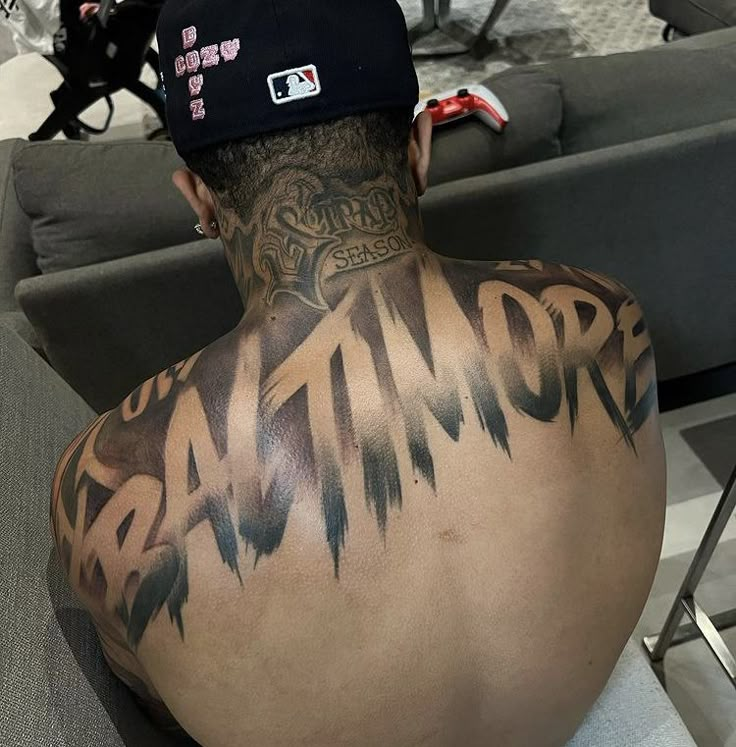 the back of a man's head with tattoos on it