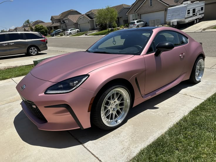 a pink sports car parked in front of a house