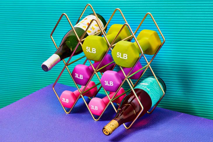 a wine rack filled with lots of different colored dumbs next to a blue wall