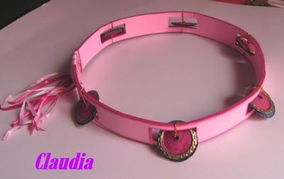 a pink belt with buttons and tassels on the bottom is sitting on a table