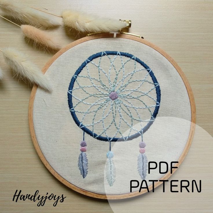 an embroidered dream catcher with feathers on it