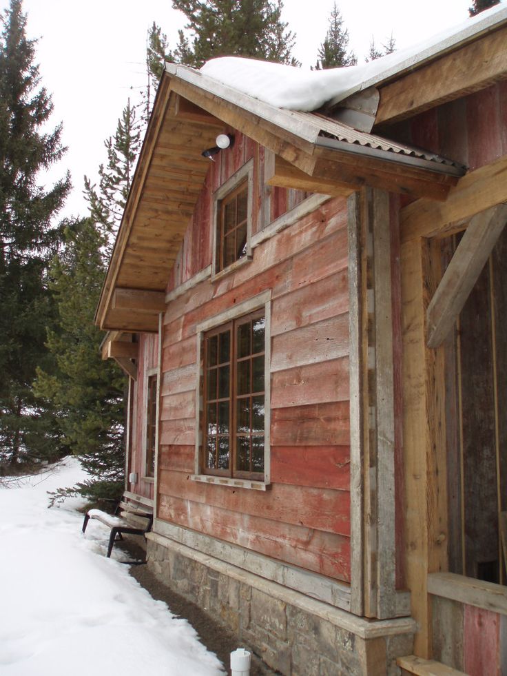 an old wooden house with snow on the roof