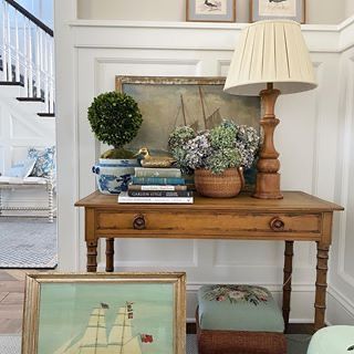 a living room with a table and pictures on the wall