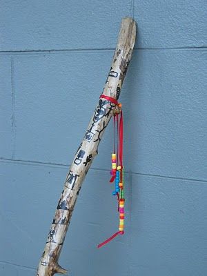 a wooden stick hanging on the side of a building with colorful beads attached to it