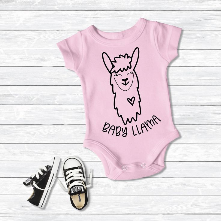 a pink onesuit with the words baby llama printed on it next to sneakers