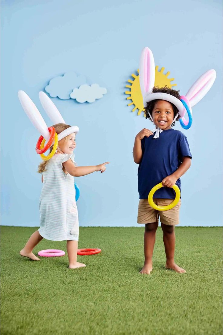 two young children are playing with toys in the grass