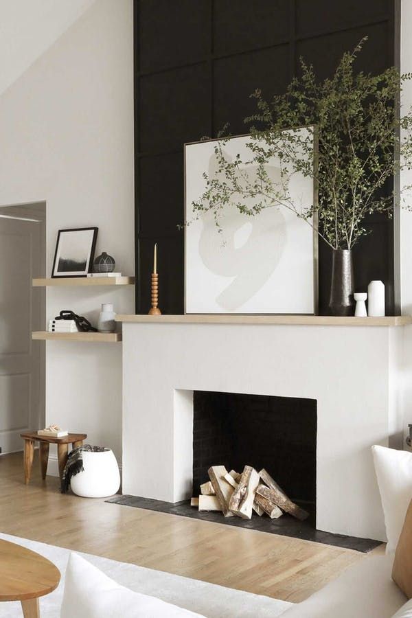 a living room filled with furniture and a fire place in front of a white fireplace