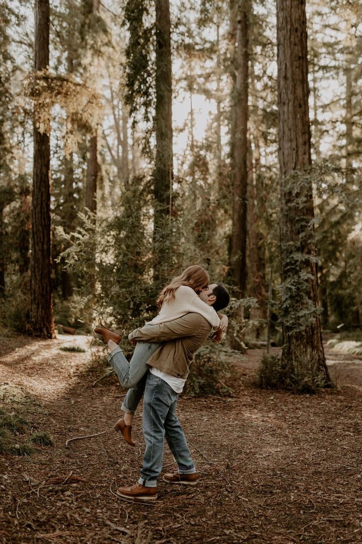 a man carrying a woman in the woods