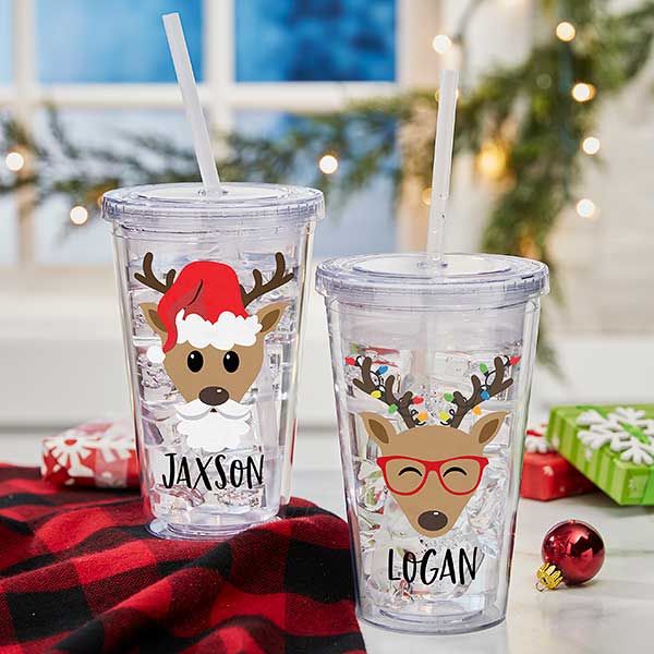 two personalized christmas tumblers with reindeer faces and glasses on them, sitting next to each other