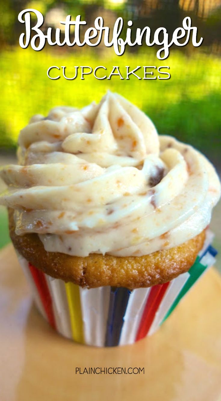 a cupcake with white frosting on top sitting on a table next to a fork