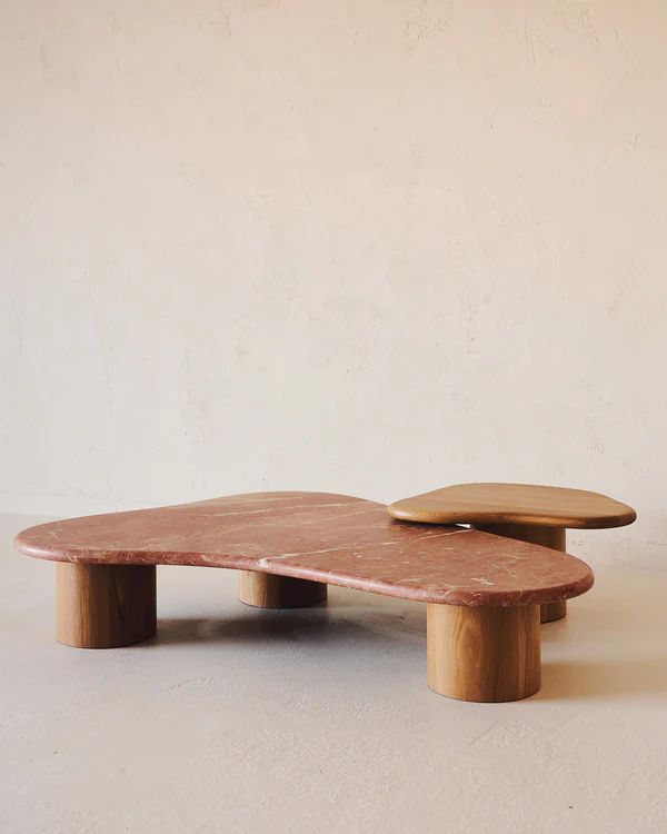 a wooden skateboard sitting on top of a white floor next to a beige wall