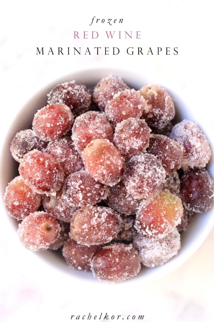 red wine marinated grapes in a bowl with powdered sugar on top and text overlay that reads frozen red wine marinated grapes