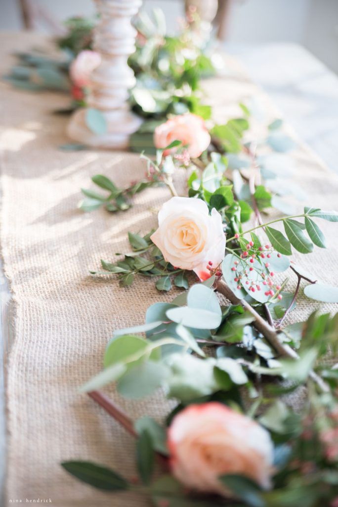 a long table with flowers and greenery on it