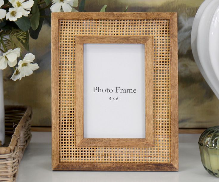 a wooden frame sitting on top of a table next to vases with flowers in them