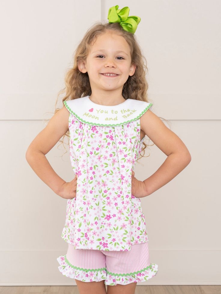 Bask in the sunny warmth of familial bonds with our latest exclusive MNC Basics collection: Family Love. Our soft, comfortable, high quality fabric is back in soft stripes, dainty florals, and ruffles galore. With embroidered messaging expressing love to the family, your little ones will love these spring basics! The perfect outfit for your little one's next adventure! This girls' shorts set features a pink floral swing top with a loving green embroidered message of "🩷 You to the Moon and Back" Spring Sleepwear With Ruffles, Fitted Cotton Sleepwear For Spring, Fitted Cotton Sleepwear With Ruffles, Spring Fitted Ruffled Sleepwear, Fitted Ruffled Sleepwear For Spring, Spring Fitted Sleepwear With Ruffles, Playful Sleeveless Top For Sleepovers, Fitted Cotton Top For Bedtime, Cute Floral Print Sleepwear For Spring