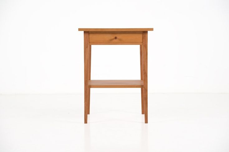 a small wooden table sitting on top of a white floor