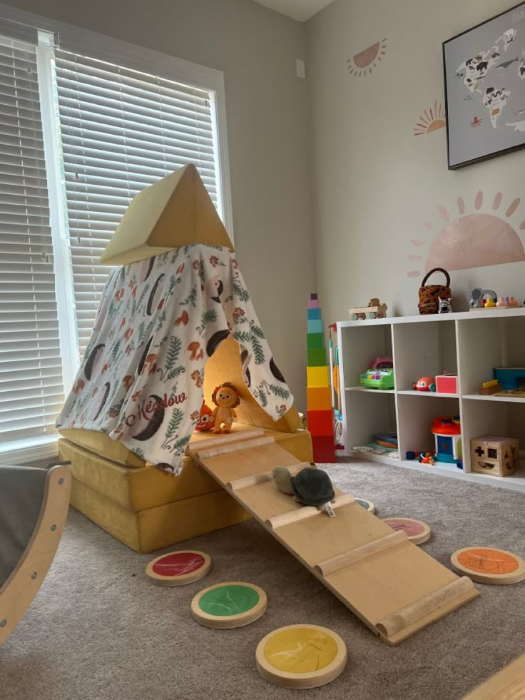 a child's play room with toys on the floor, and a teepee tent in the corner