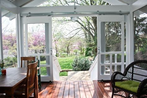 a porch with wooden floors and white walls