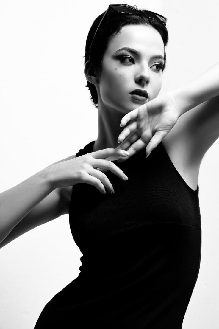 a black and white photo of a woman with her arm extended in front of the camera