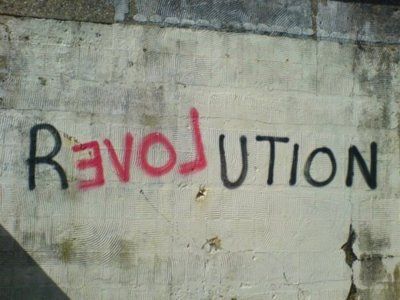 graffiti on the side of a building that says revolution written in black and red spray paint