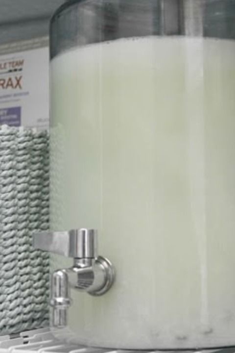 a large glass container sitting on top of a shelf next to a towel dispenser