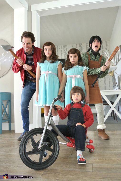 a group of people standing next to each other in front of a child's tricycle