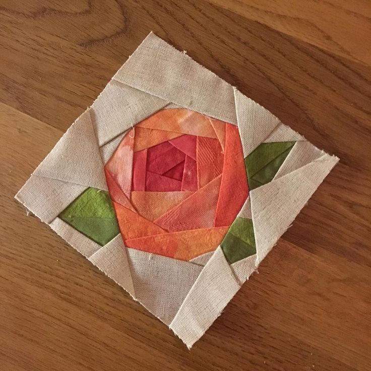 an orange flower is sitting on top of a piece of fabric