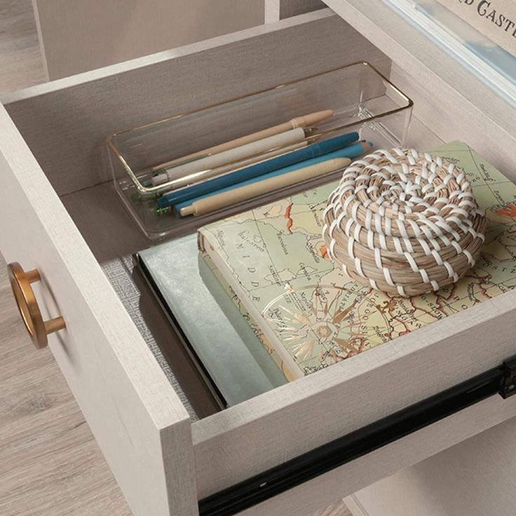 an open drawer with books and pencils in it