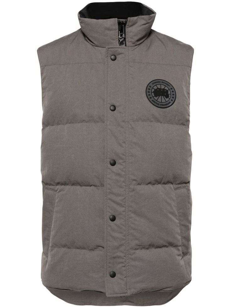 grey cotton blend duck down logo patch at the chest padded design high neck front press-stud and zip fastening sleeveless rear curved hem Casual Cotton Puffer Vest, Outdoor Cotton Outerwear With Logo Patch, Winter Cotton Outerwear With Logo Patch, Cotton Outerwear With Logo Patch For Outdoor, Cotton Puffer Vest, Down Vest With Padded Collar, Casual Cotton Vest With Padded Collar, Gray Sleeveless Vest For Outdoors, Gray Sleeveless Vest For Outdoor