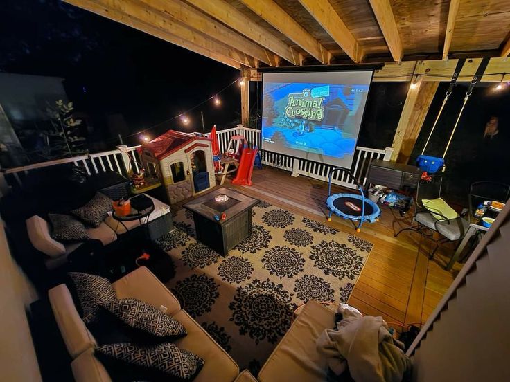 a living room filled with furniture and a projector screen in the middle of it