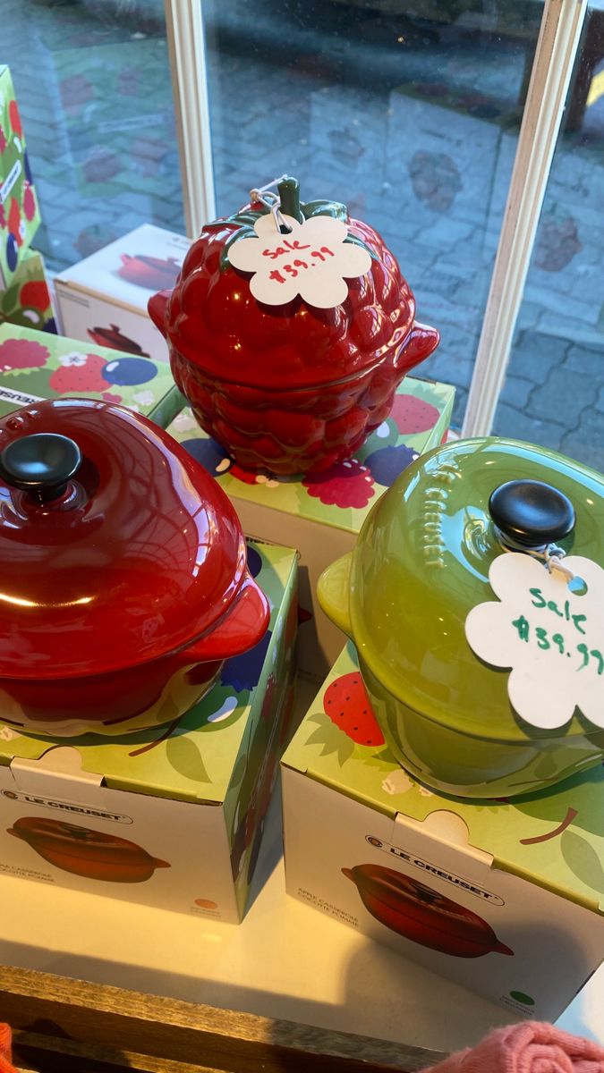 three red and green dishes on display in front of a window with the words hello kitty written on them