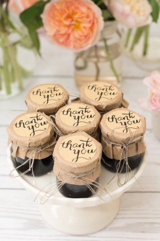 small wine bottle corks with thank you written on them sitting on a white plate