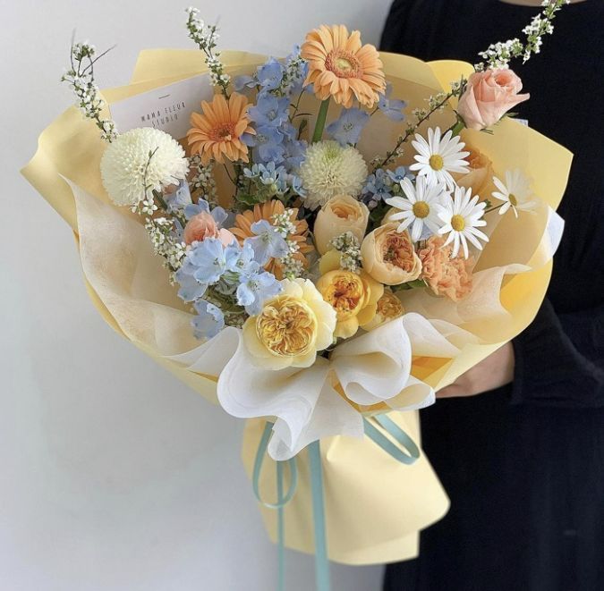 a woman is holding a bouquet of flowers