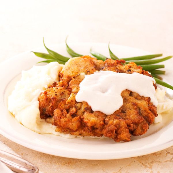 a white plate topped with mashed potatoes and fried chicken