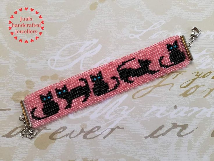 a pink beaded key chain with black cats on it