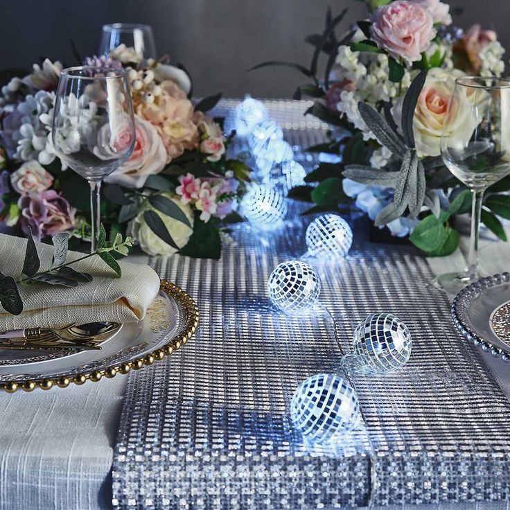 a table topped with plates and vases filled with flowers