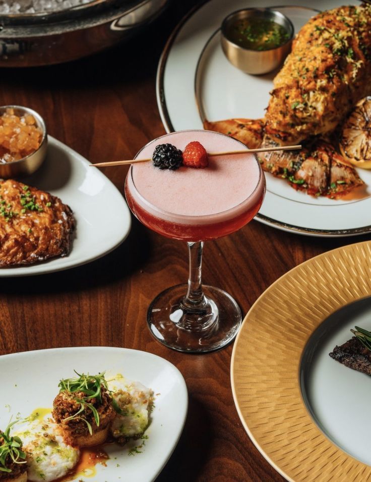 a table topped with plates and glasses filled with different types of food on top of it