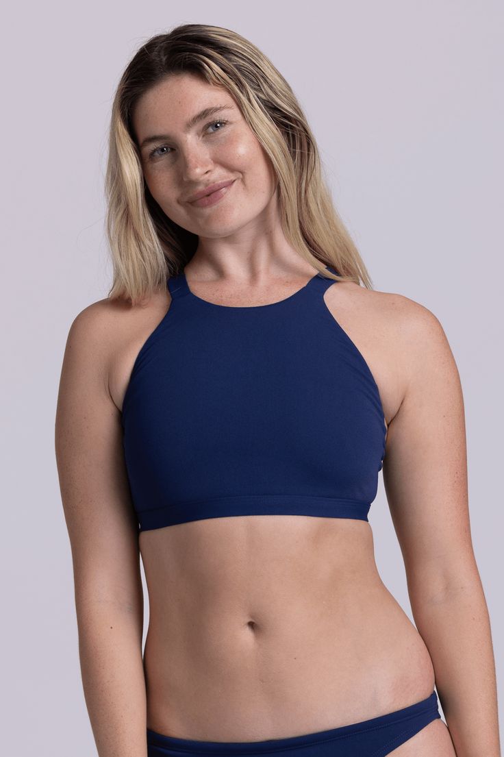 The Kaylee is a high neck, full coverage bikini top with thick straps in the back for the best support. This swimsuit top can double as a sports bra - rock the Kaylee at a hot yoga class or at swim practice - whatever suits your style! Features: Good for: Swim, Water Polo, Surfing, paddling, ocean activities, pool activities, lifestyle Fixed-Back Thick Strapped Swim Top + Sports Bra Full Coverage High Impact Unpadded Tagless Lined for maximum privacy Chlorine proof 2-way stretch Reinforced stitc Sporty T-back Halter Top For Sports, Seamless T-back Halter Top For Yoga, Sporty Halter Neck Swimwear With Built-in Bra, Athleisure T-back Swimwear, Bra Friendly, Stretch Swimwear With Light Support For Beach, Sports Halter Neck Tankini With Built-in Bra, Solid T-back Swimwear For Workout, Sporty Bra-friendly Tankini For Yoga, Sporty Solid Color Swimwear For Pilates