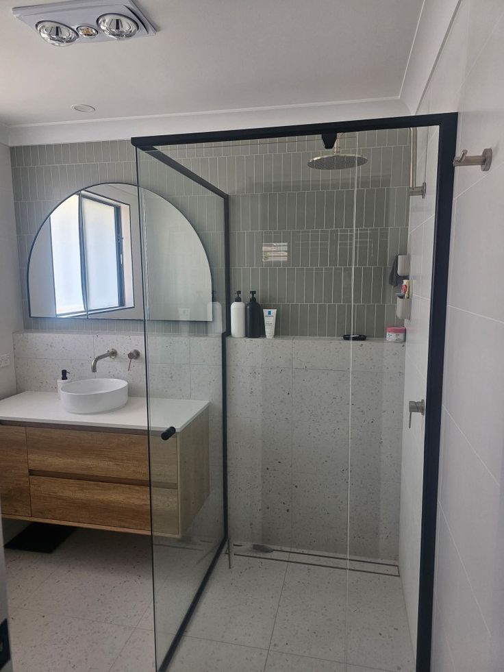 a bathroom with a walk in shower next to a sink