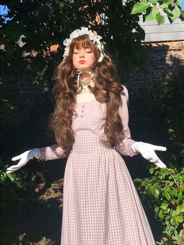 a woman in a dress with long brown hair and white gloves is posing for the camera