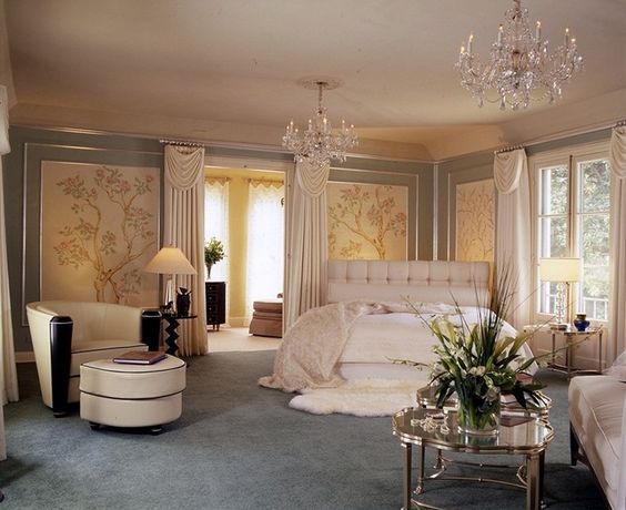 a bedroom with chandelier, bed and chairs in it