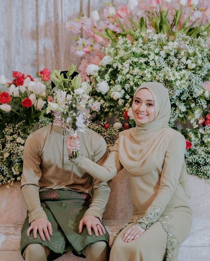 two women sitting next to each other in front of flowers