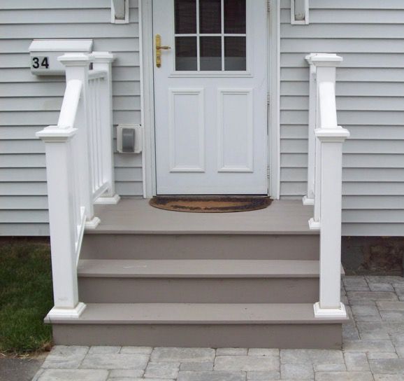 a white door and some steps in front of a house