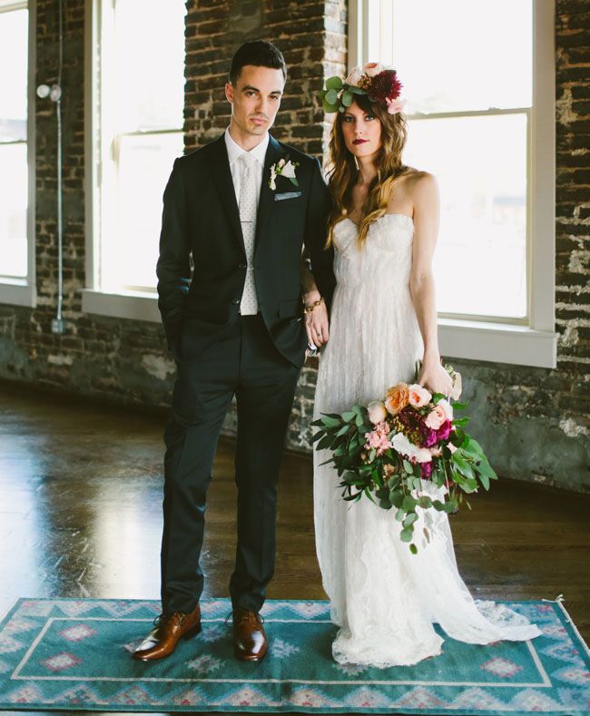 a bride and groom standing on a rug in an old building with exposed brick walls