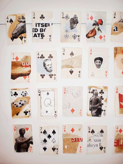 several playing cards are arranged on a white surface with black and red images all over them