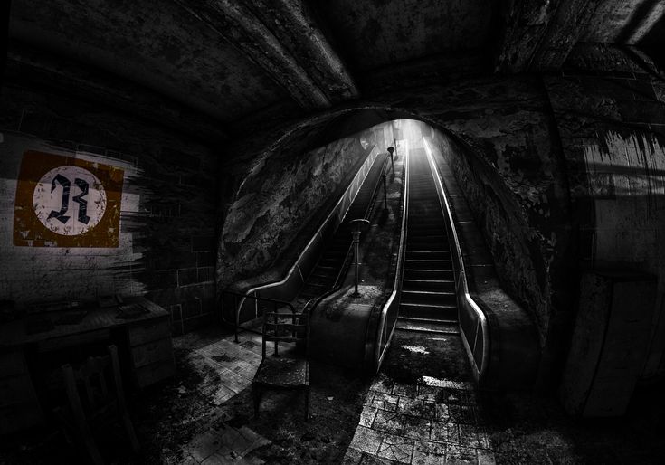 a dark tunnel with an escalator and stairs