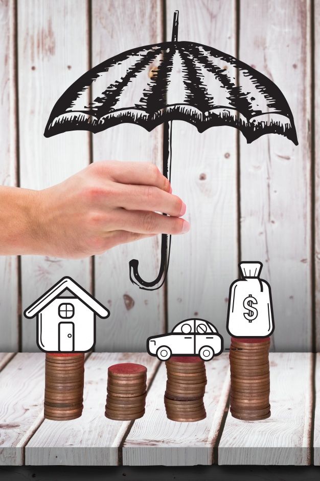 a hand holding an umbrella over stacks of coins with houses and cars drawn on them