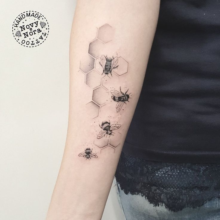 a woman's arm with honeycombs and bees tattoo on the left forearm